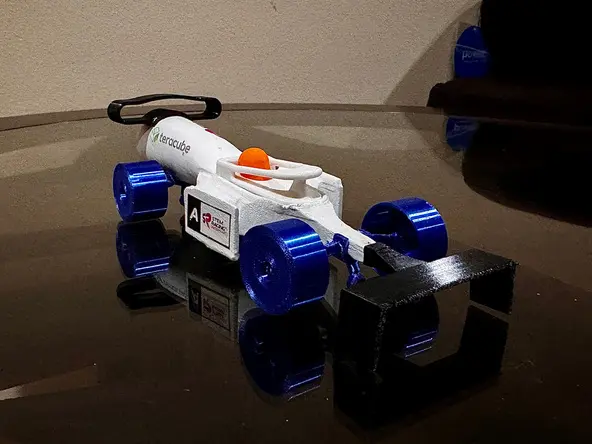 The finished Aventus Racing car: white CNC-machined body, blue 3D-printed wheels and black wings