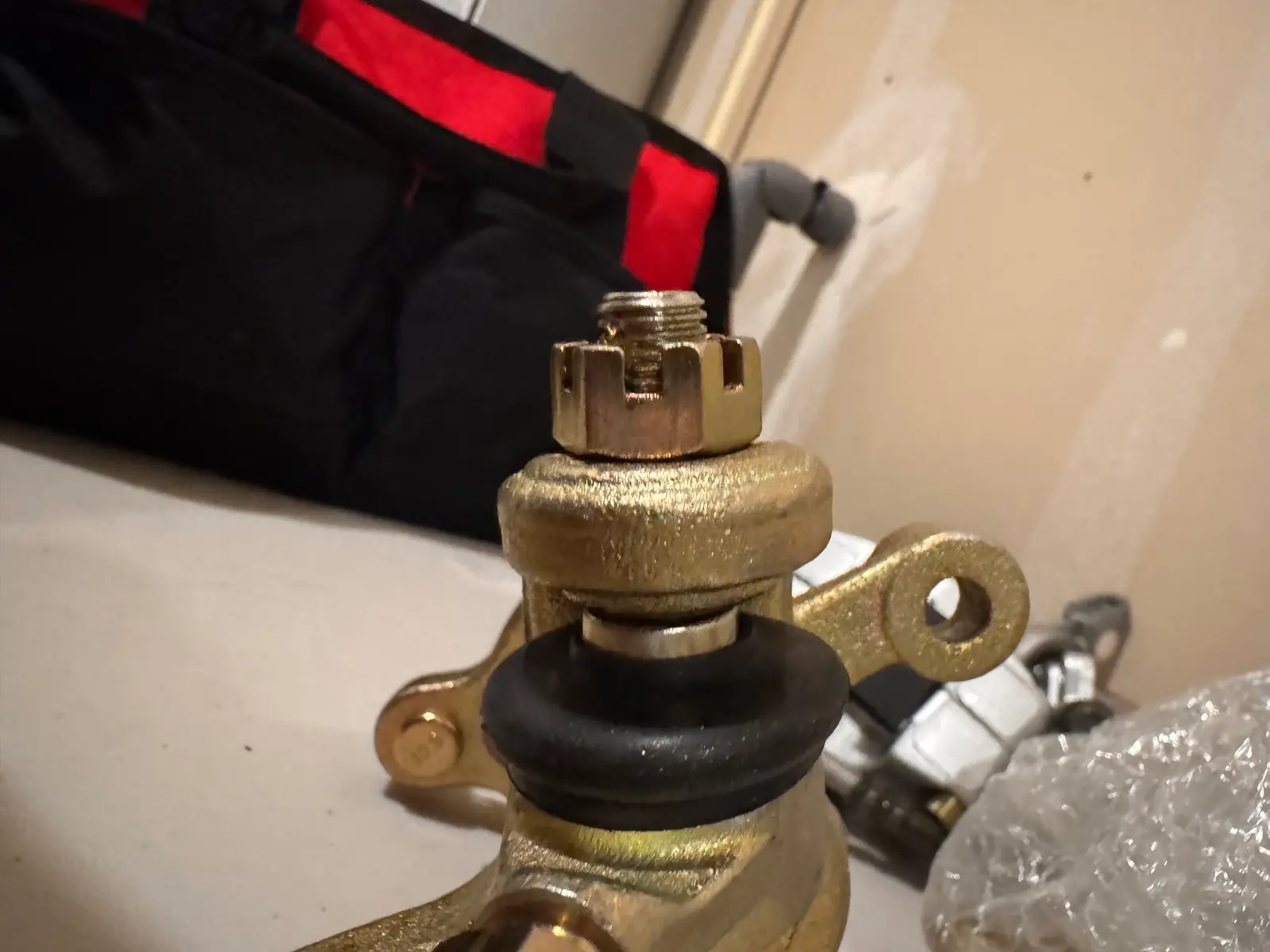 Close-up of a steering spindle with a castle nut and tie-rod end