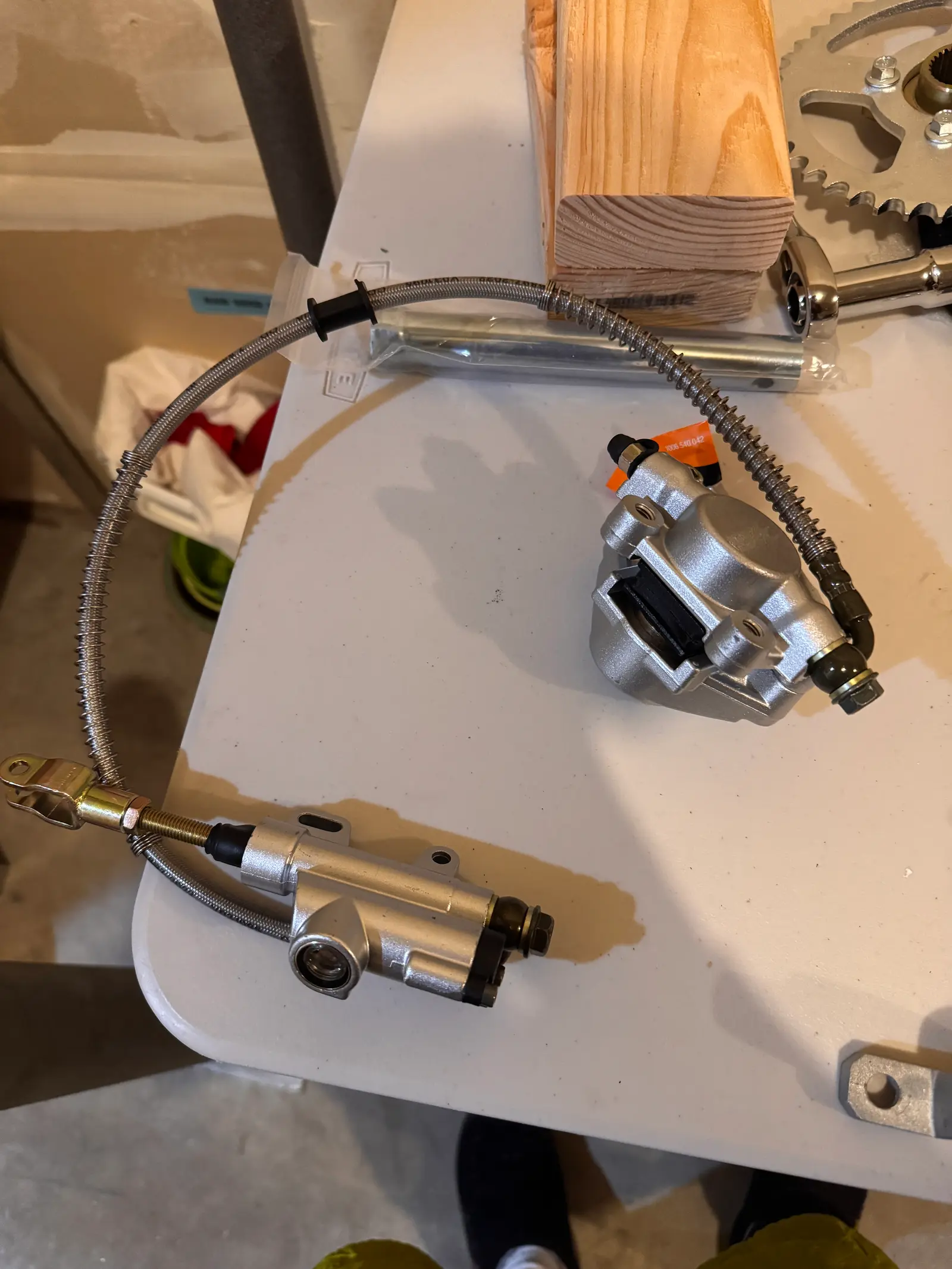 Hydraulic brake master cylinder and caliper with braided brake line on a workbench