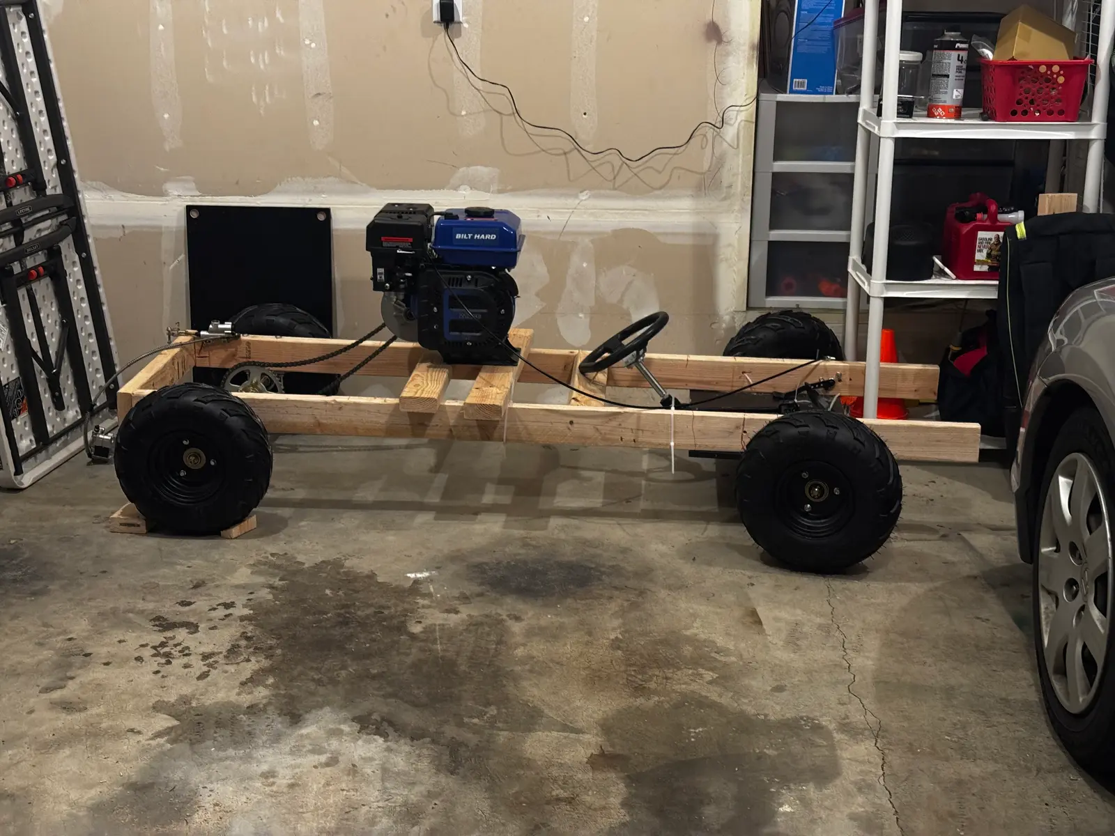The finished wood go-kart parked in the garage, seen from the side