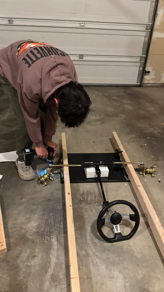 Kneeling beside the frame, working on the brake assembly